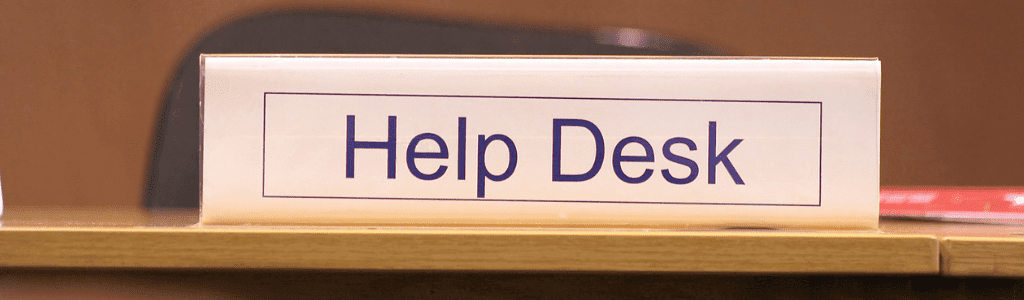 A desk with a plaque that reads Help Desk.