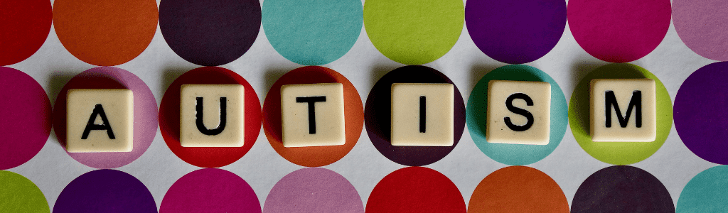 Decorative: Autism Awareness Month image. Letter blocks spelling 'Autism' are displayed on a colourful polkadot coloured surface.