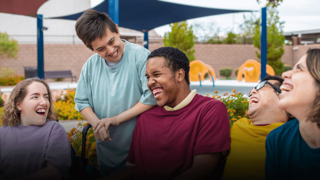 People with learning disabilities enjoying each other's company, laughing and smiling together.
