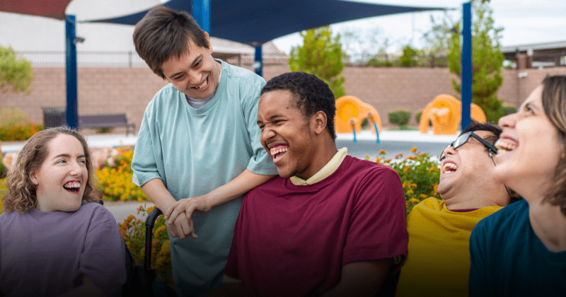 People with learning disabilities enjoying each other's company, laughing and smiling together.