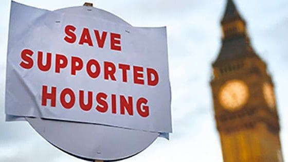 Protest sign for supported housing near clock tower.