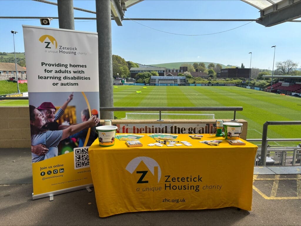 Zetetick Housing charity booth at football stadium.