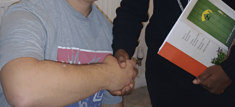 Two people shaking hands indoors.