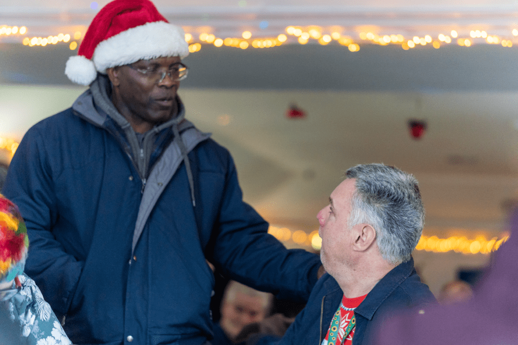 Two men talking at festive event.